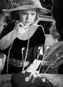 Girl blowing out candles on birthday cake