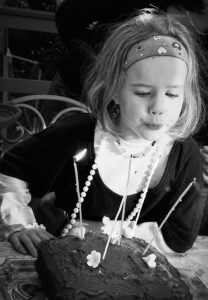 Girl blowing out candles on birthday cake